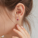 STMG Red Ruby Hoops in silver on ear