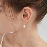 STMG Natural Pearl Dangle Hoops in gold on ear