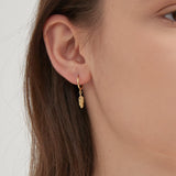 Feather Dangle Hoops in gold on ear