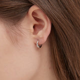 STMG Irregular Twisted Circle Hoops in silver on ear