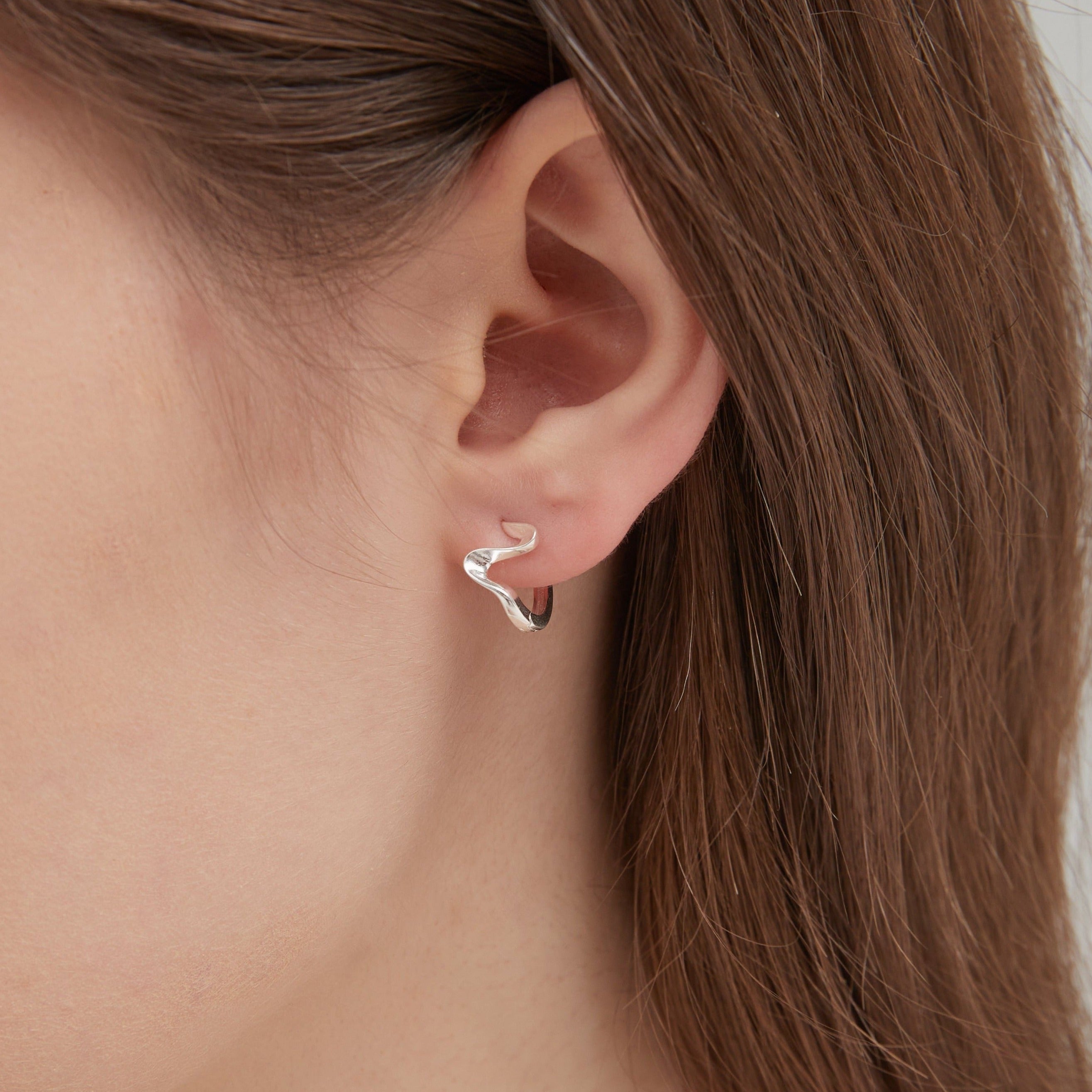 STMG Geometric Wave Hoops in silver on ear