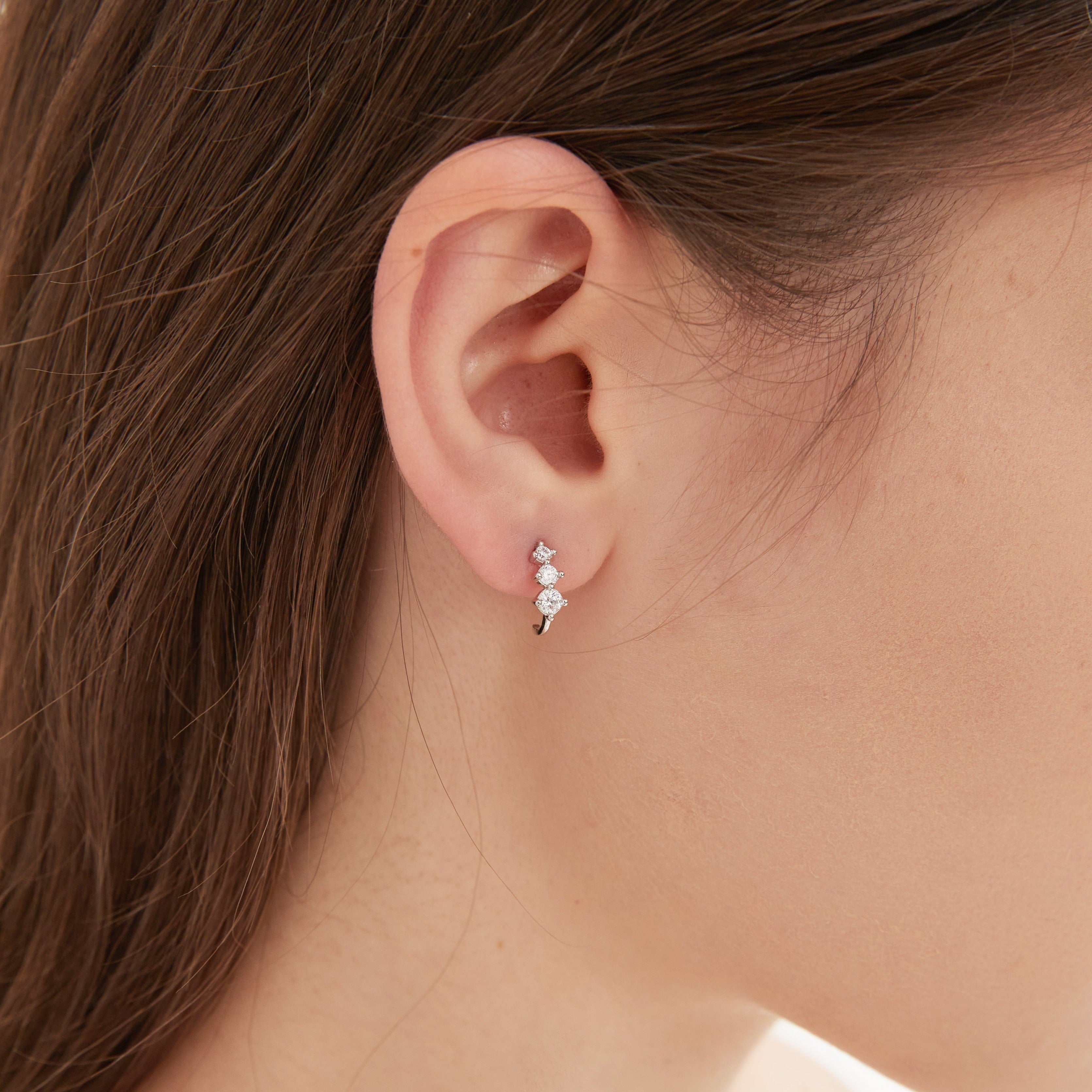 Curved Tiny Stud Earrings in silver on ear