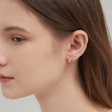 Curved Tiny Stud Earrings in gold on ear