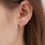 Curved Tiny Stud Earrings in gold on ear