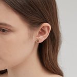 STMG Tiny Black Flower Stud Earrings on ear