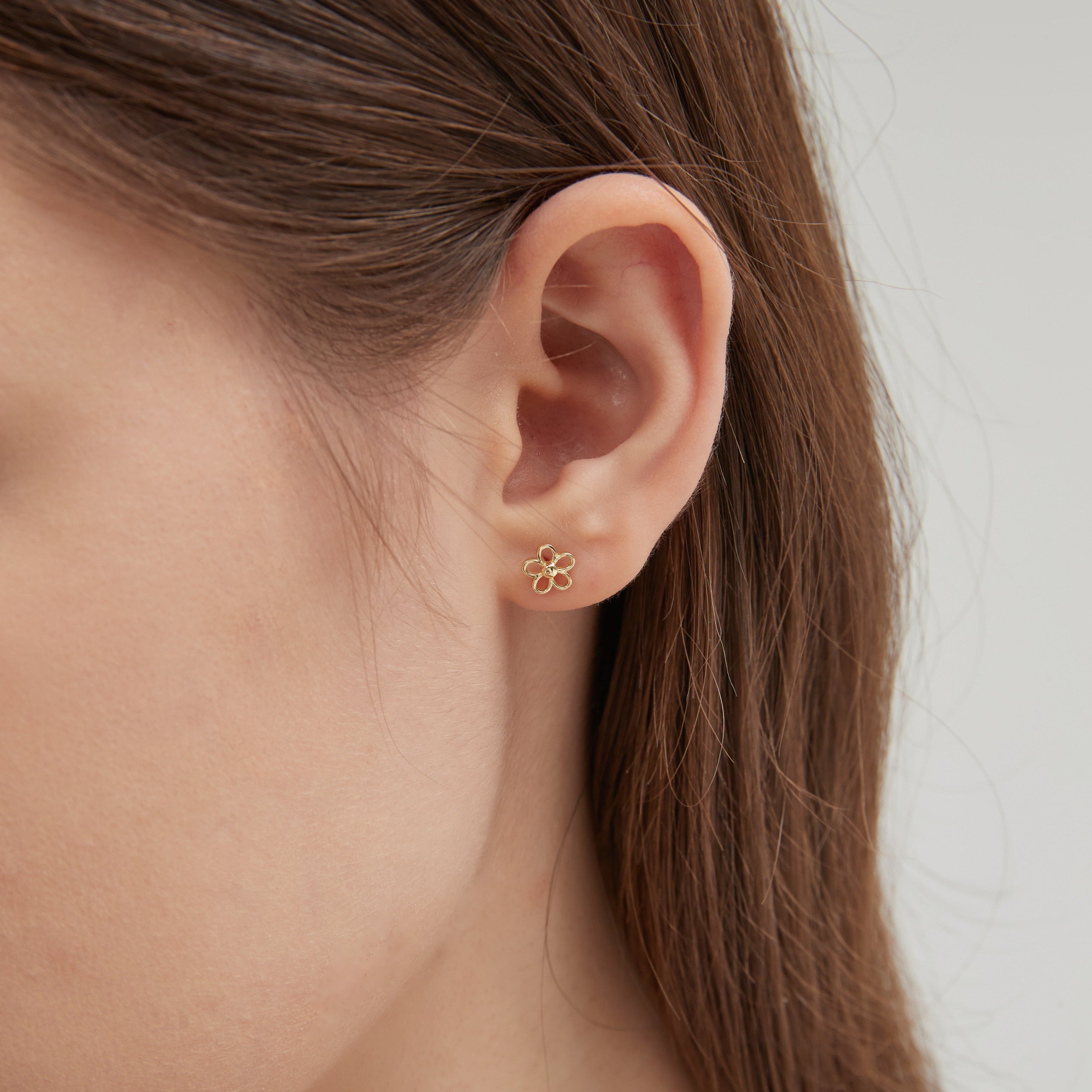 STMG Tiny Flower Stud Earrings in gold on ear