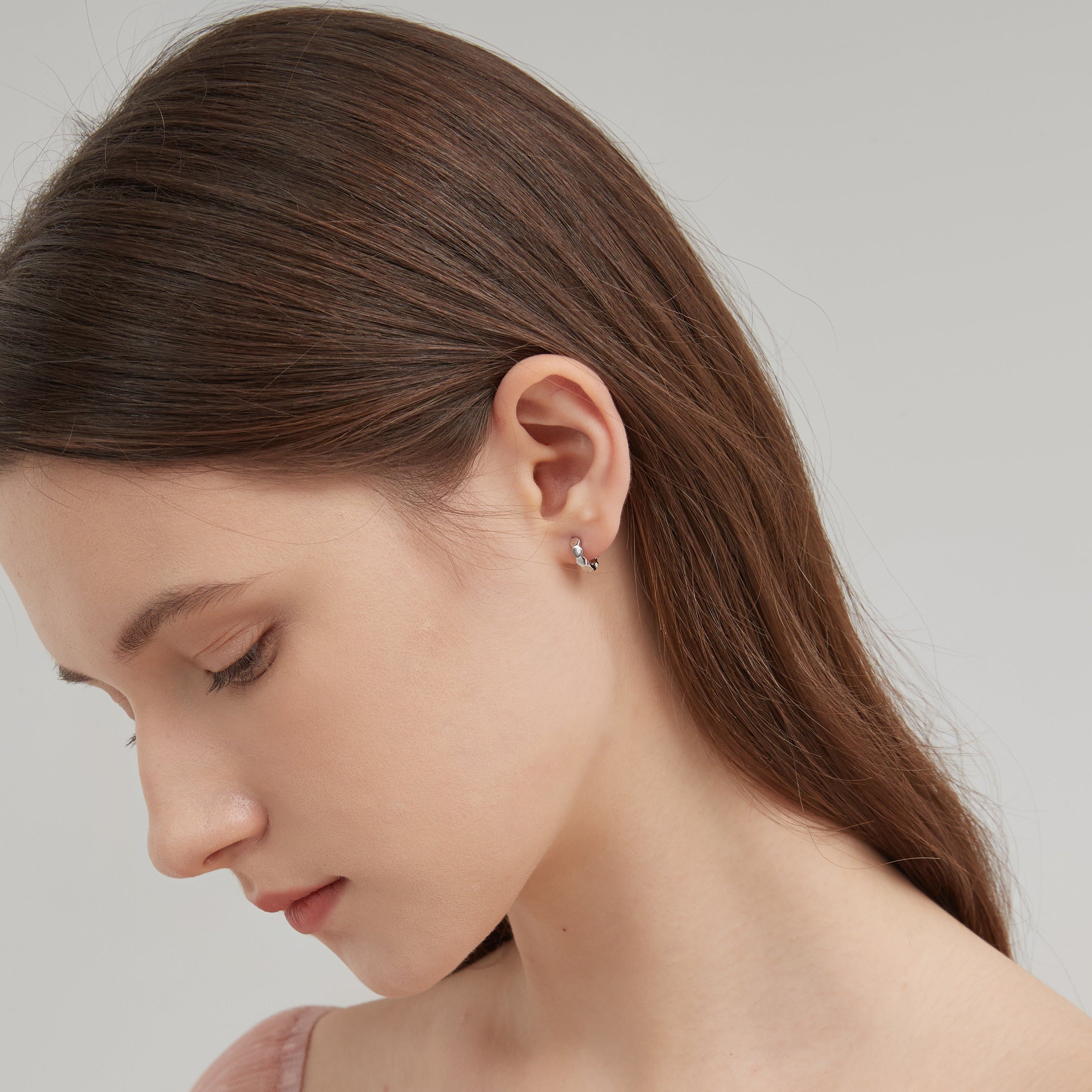 STMG Minimalist Hexagon Hoops in silver on ear