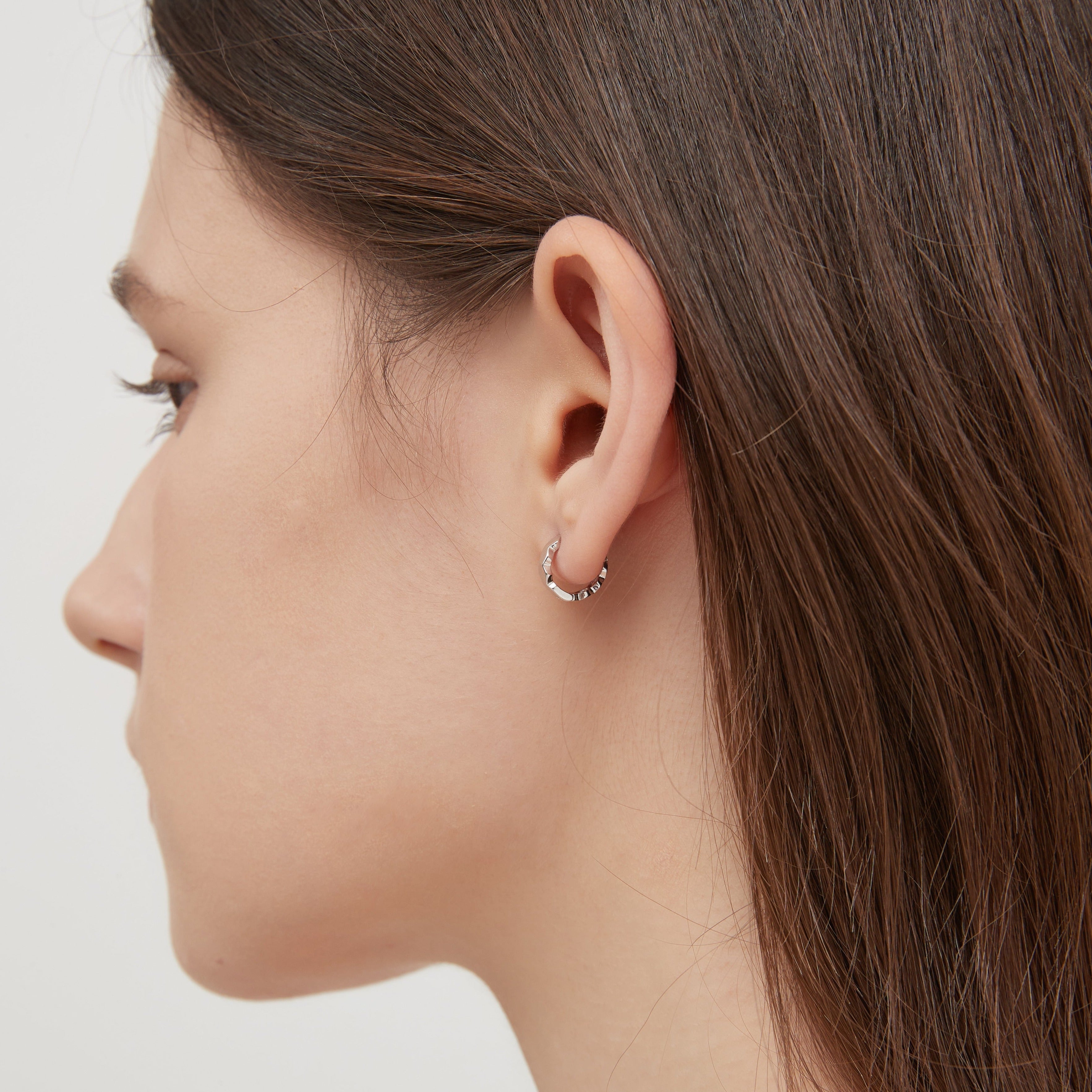 STMG Minimalist Hexagon Hoops in silver on ear