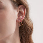 Geometric Cross Hoops in gold and rose gold on ear