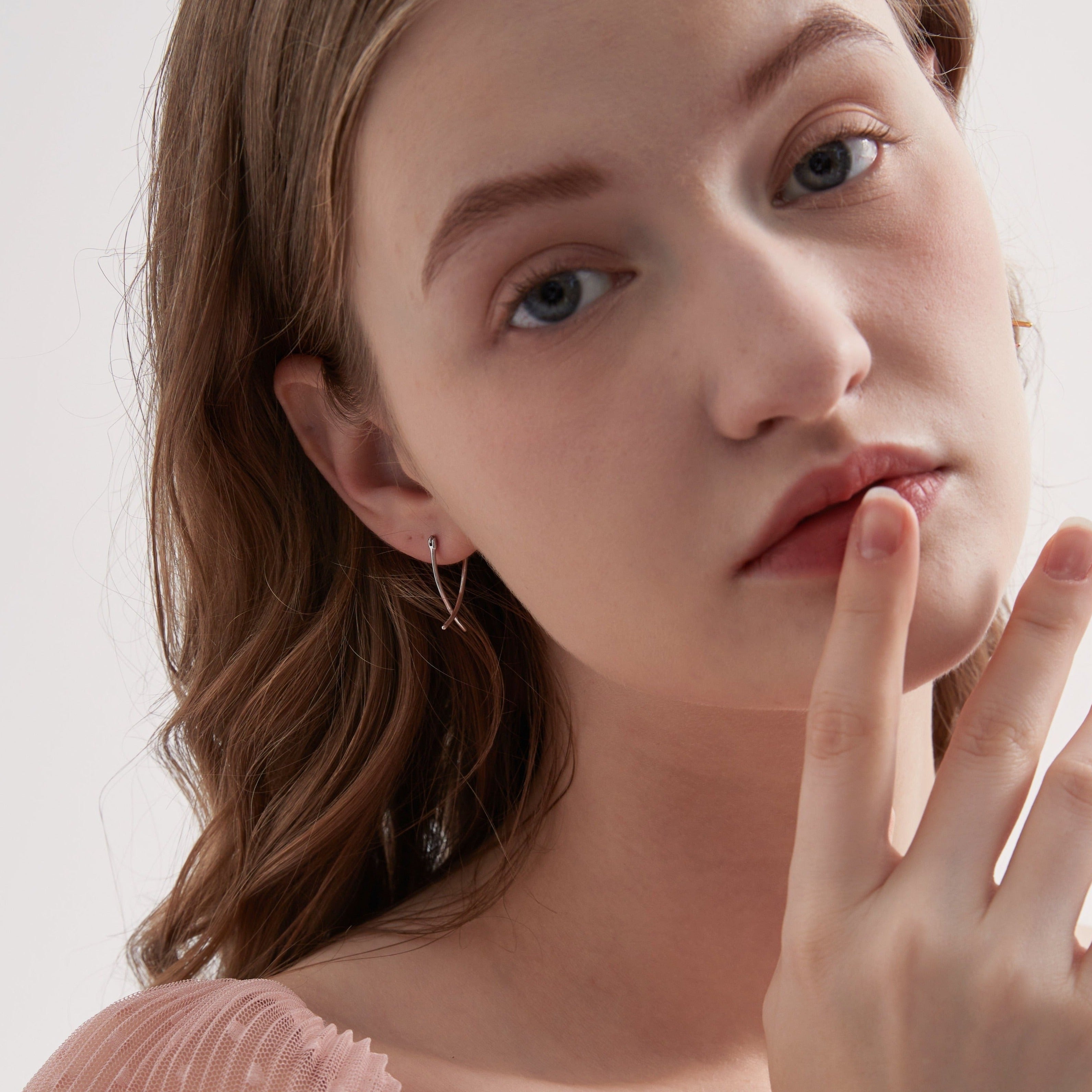 Geometric Cross Hoops in silver on ear