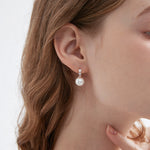 STMG Pearl Dangle Hoops in champagne gold on ear