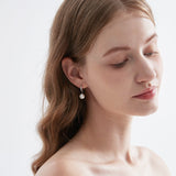 STMG Pearl Dangle Hoops in silver on ear