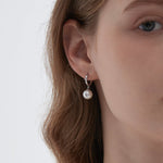 STMG Pearl Dangle Hoops in silver on ear