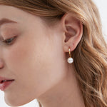 STMG Pearl Dangle Hoops in gold on ear