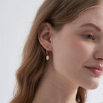 STMG Natural Pearl Dangle Hoops in gold on ear