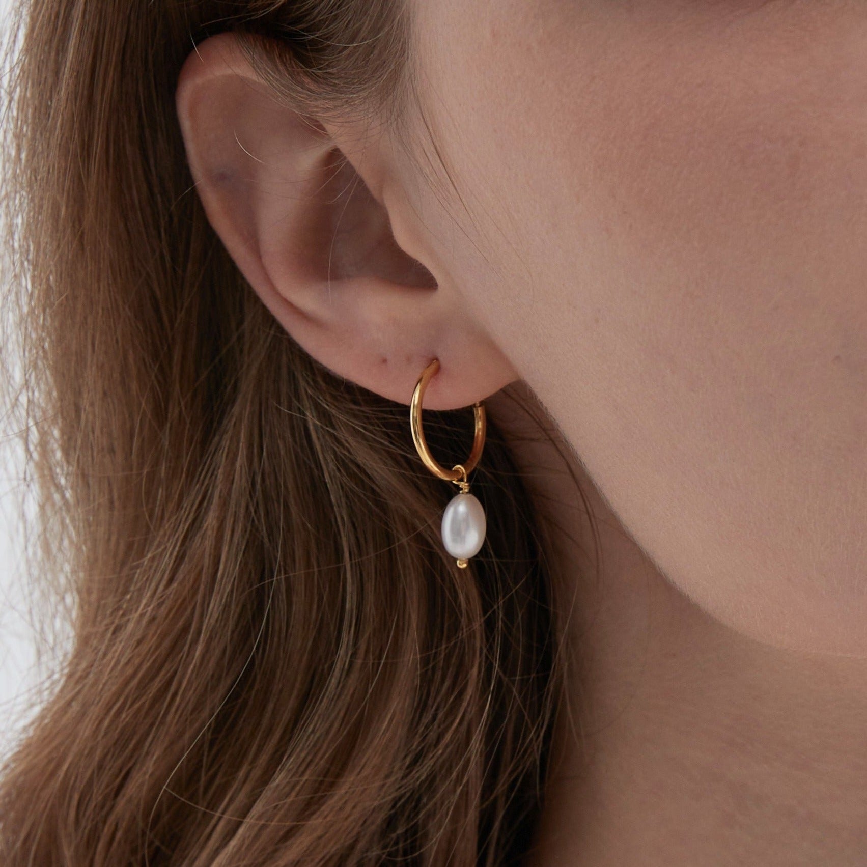 STMG Natural Pearl Dangle Hoops in gold on ear