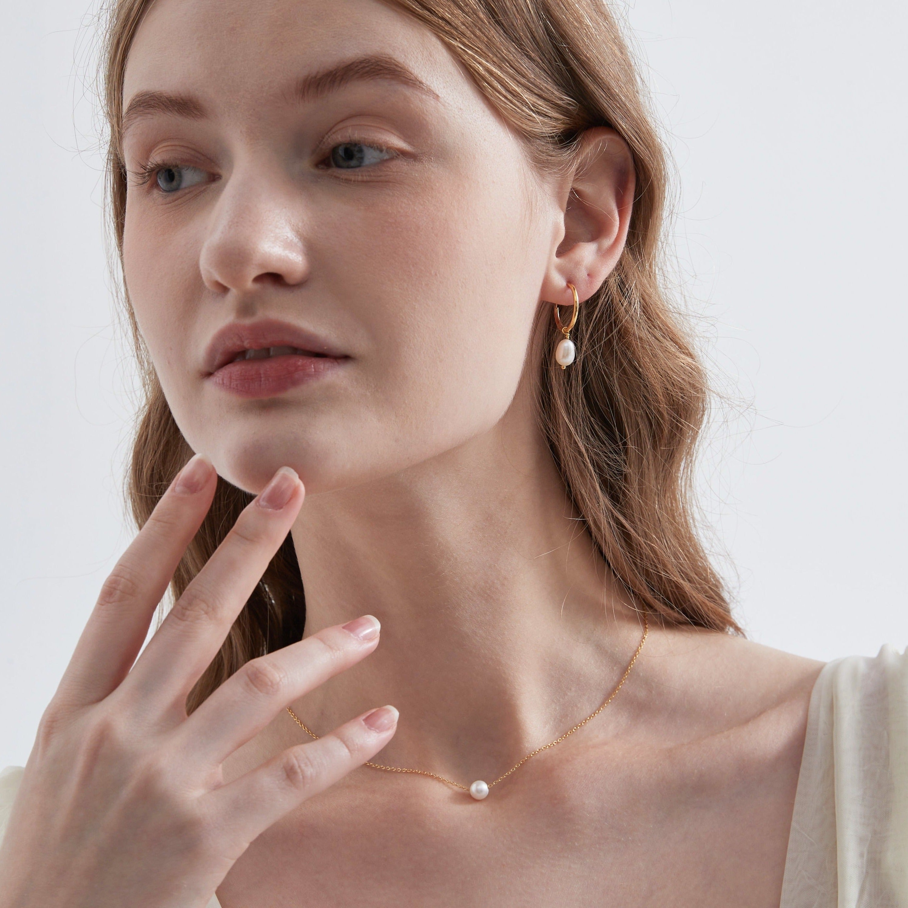 STMG Natural Pearl Dangle Hoops in gold on ear